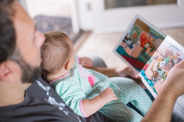 photo papa lit un livre à son bébé